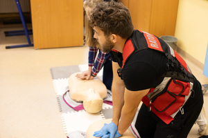 Zdjęcie przedstawia: ratownika medycznego podczas pokazu pierwszej pomocy.