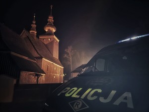Zdjęcie przedstawia: policyjny radiowóz, z tyłu widoczny kościół.